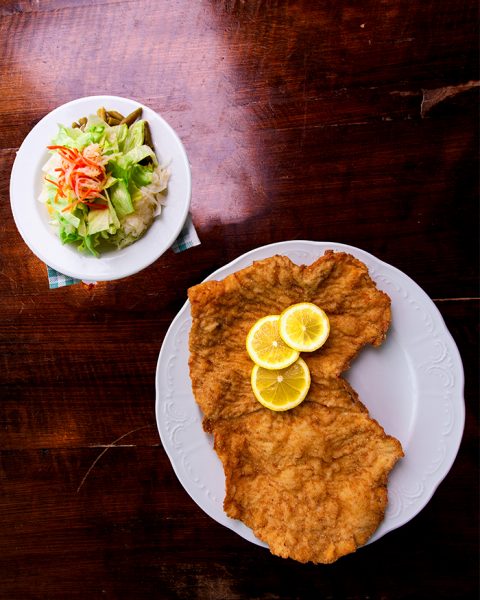 Plate of schnitzel and side salad on a table